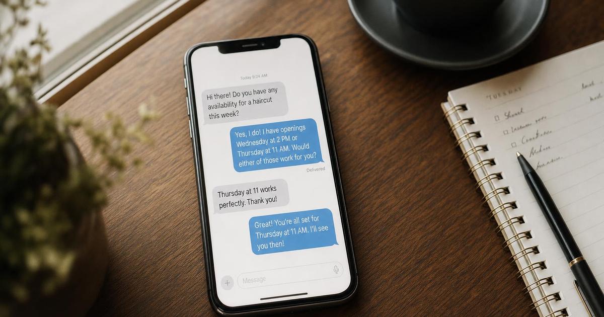 A smartphone on a desk showing an automated text-message follow-up conversation with a small business